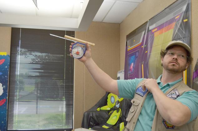 Scott Cantrell explained how UFO reports can be classified under a variety of categories by MUFON. He is shown with a tool used to gauge the angle of an object spotted, in relation to the horizon. (Photo/Stephanie Hill)