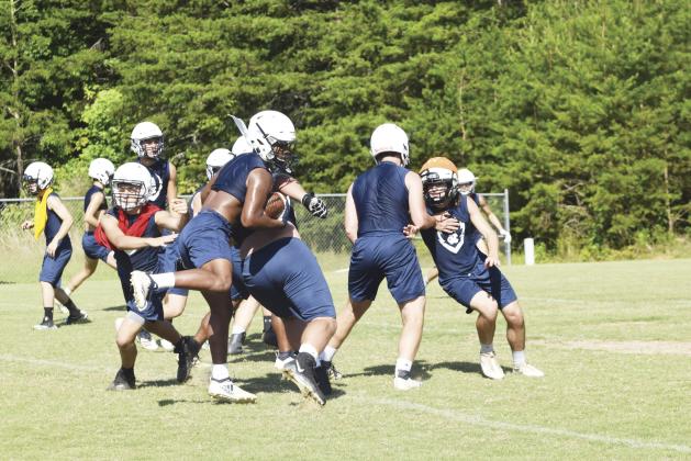 WCHS sophomore running back Zion McMullen bounces off a block by Jacob Anderson during the team's workout Tuesday morning at the football complex.  (Photo/Mark Turner)