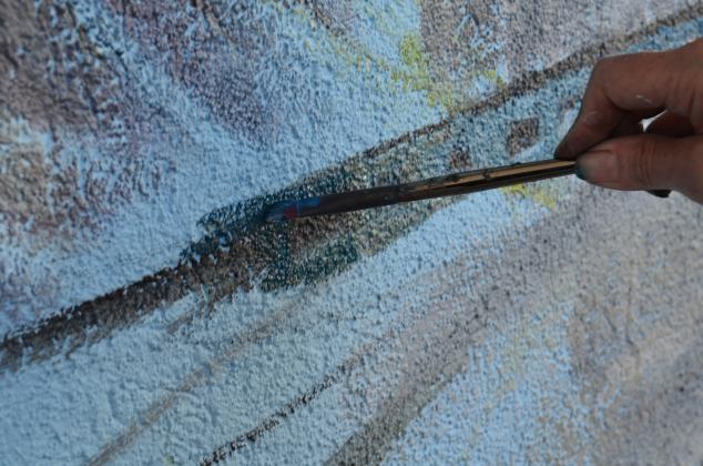 Anna Wilkins paints some of the details on the new mural in Helen. (Photo/Stephanie Hill)