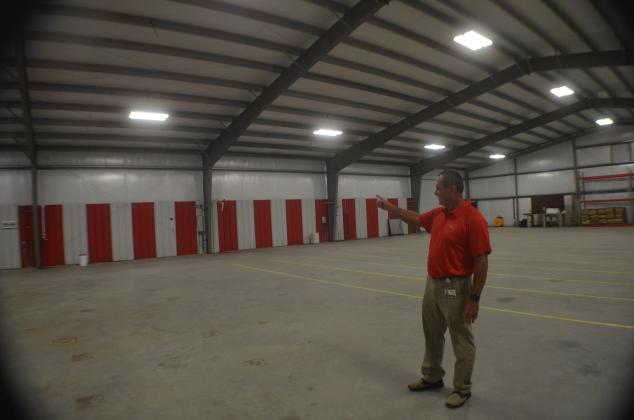 Mountain Education Charter High School Assistant Superintendent Tracy Sanford points to the back wall of the system’s new transportation and storage facility, where new bay doors will be installed. The building is the former site of Sautee Hard Cider on Helen Highway. (Photo/Wayne Hardy)