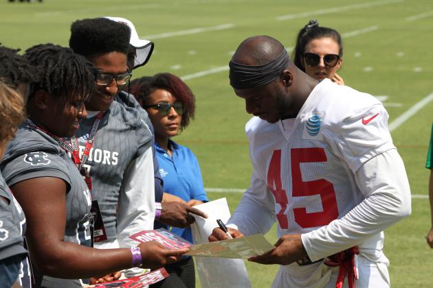 Jaquez Williams and Zion McMullen get an autograph from linebacker Deion Jones.