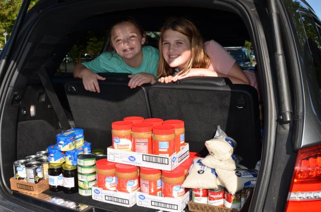 Mary Nix and Grace Smidt launched a drive to support community food pantries. They’re shown after a recent shopping trip to pick up items to donate. (Submitted photos)