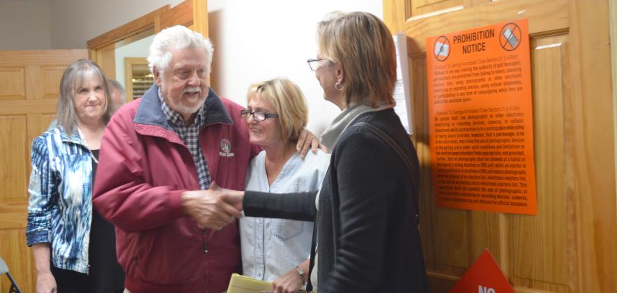 Fred Garmon and Cinnamon Spurlock shake hands after Helen election results are announced. Former city commissioner Dona K. Burke is shown in the middle. (Photo/Stephanie Hill)