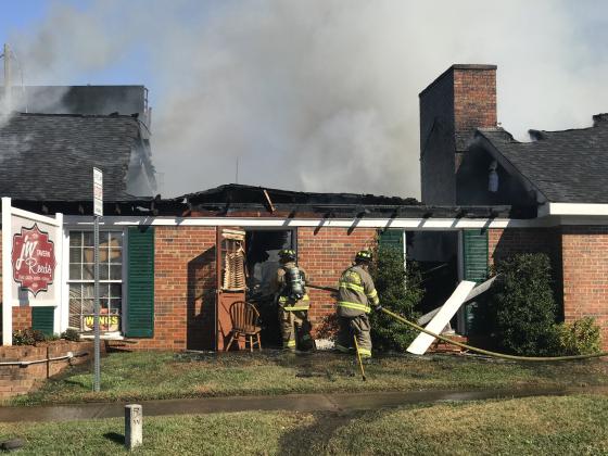 Firefighters carried a hose inside JW Reeds Tavern as they looked for hot spots. (Photo/Stephanie Hill)