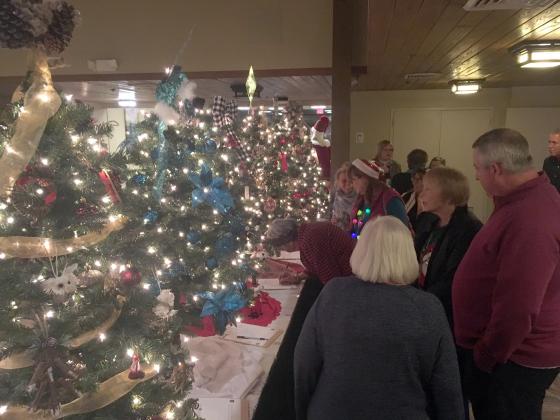 Guests had the opportunity to make last-minute bids on Christmas trees, sponsored by community businesses and organizations. (Photo/Wayne Hardy)