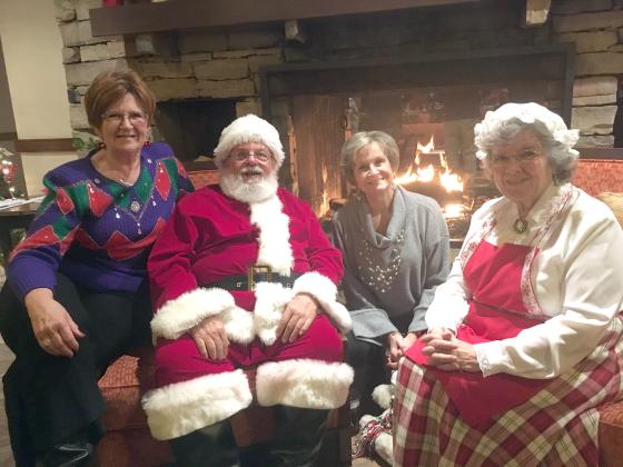 At right (from left), Brenda Helton, Santa Claus, Carol Jackson and Mrs. Claus enjoy a chat by a fireplace in the Unicoi lodge. (Photo/Wayne Hardy)