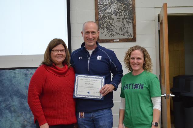 Superintendent Dr. Laurie Burkett, left, and WCHS principal Mary Anne Collier, right, present a certificate to Craig Turner. (Photo/Stephanie Hill)