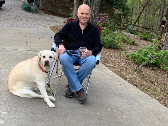 Wallace Joslyn, with dog S’nuvi, stands in for Dr. Barbara Camp, who is working with Phoenix Air, transporting Covid-19 patients. (Photo/Ivy Rutzky)