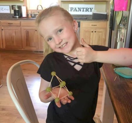 Makalli McMillian proudly shows off her 3-D toothpick shapes project.
