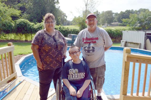 Trevor pictured at his pool with Lisa Hall, his nana, and Stanley Thompson, his papa. (Photo/Stephanie Hill)