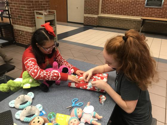 Brooke Puffer and Layla Herbert with Project Unify work together to wrap a present. (Submitted photo)