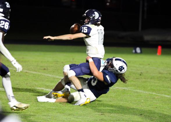 White County's Dylan Archer wrestles West Hall quarterback Clayton Jenkins to the ground for a 9-yard loss during the Warriors' 35-0 win over the Spartans last Friday in Cleveland. (Photo/Staci Sulhoff)