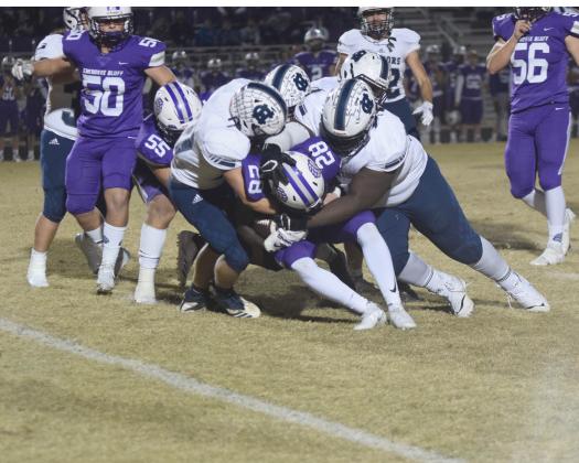 Riley Stancil, left, and Heaven Gholston, right, lead a pack of Warrior defenders as they smother Cherokee Bluff running back Jayquan Smith for a loss during the opening quarter of the regular season finale last Friday night in Flowery Branch. (Photos/Mark Turner)