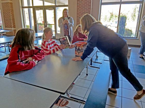 Students were all smiles as they received the games from Hasbro. Pictured is White County School System Superintendent Laurie Burkett giving a Clue game to a student. (Photo/Stephanie Hill)