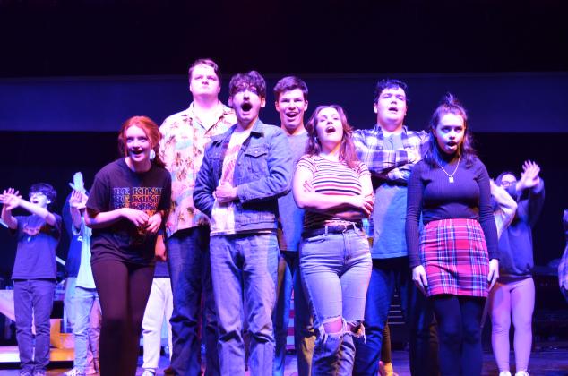 Pictured, from left to right, are Doni Martin as Grandma, Tim Behan as Lurch, Ben Perrin as Gomez Addams, Colin Baughman as Fester, Ireland Ballington as Morticia Addams, Gabe Talafous as Pugsley, and Molly Cutchshaw as Wednesday Addams, during rehearsals on Tuesday, March 9. (Photo/Stephanie Hill)