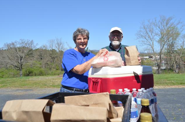 Lindalee Walters and Jim Crawford greeted visitors at a drive-thru line at the church. (Photo/Wayne Hardy)