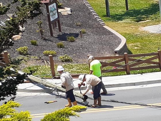 Workers exam the downed power pole. (Submitted photo)