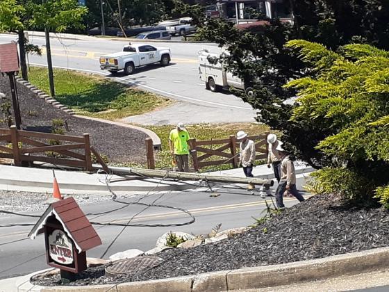 Workers exam the downed power pole. (Submitted photo)