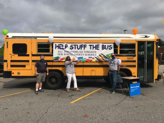The annual Stuff the Bus event is set to take place July 23-Aug. 3. Pictured is Darren Sledge, transportation director, Dr. Laurie Burkett, superintendent, and Scott Justus, assistant superintendent, with the bus in 2020. (File photo)