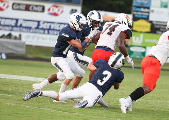 White County's Colton Turner, left, Zion McMullen, and Bryson Cronic team up to bring down Hart County running back JL Lackey during the Warriors' home opener last Friday in Cleveland. (Photo/Staci Sulhoff)