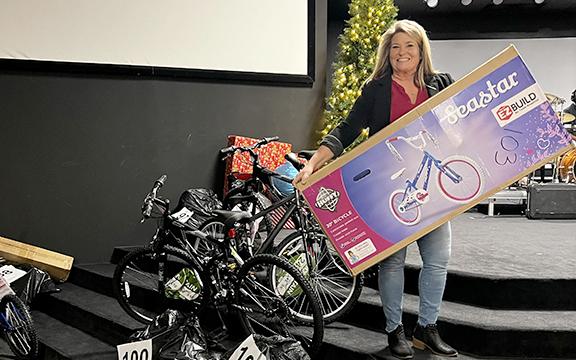 Cheryl Kennedy, associate pastor at The Bridge Church, holds one of the bicycles among the many gifts that have been donated for Family Connections’ White Christmas effort. The toys are labeled by families that have been adopted in this effort to provide Christmas to struggling families this year. Volunteers from around the county have worked in this effort. (Photo/Linda Erbele)