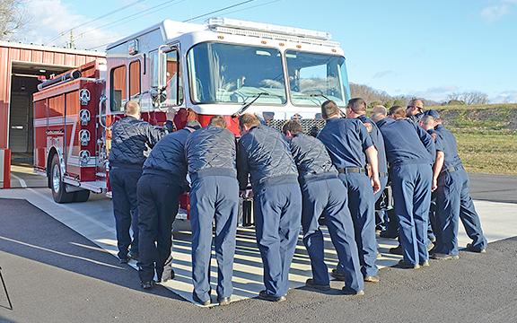 Firefighters from around the county push Engine 2 into a bay at White County Station 2. (Photos/Samantha Sinclair)