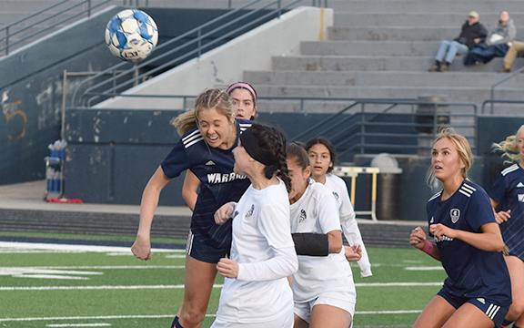 White County's Callie Armour, left, heads a ball off a corner kick during the Lady Warriors' win over West Hall Tuesday at Warrior Stadium. (Photo/Mark Turner)