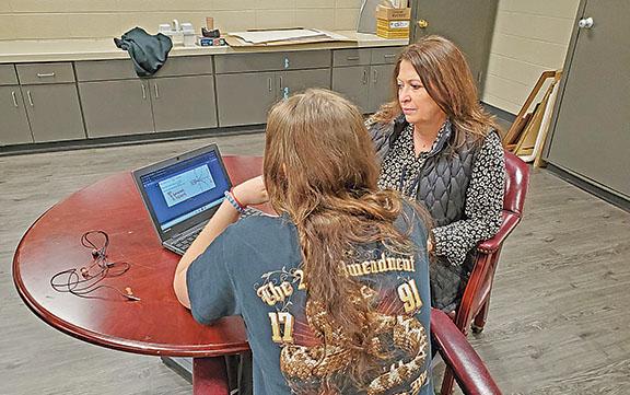 Warrior Academy Director Shelly McDonald helps Moriah Sovine with an assignment.