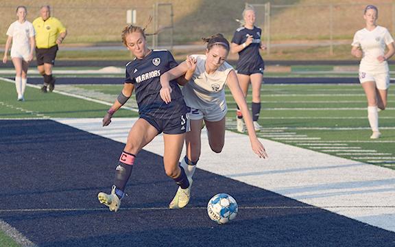 Hazen Ramey, left, battles Lumpkin County's Savannah Buck for control of the ball during the second half of the region matchup last week at Warrior Stadium. (Photo/Mark  Turner)