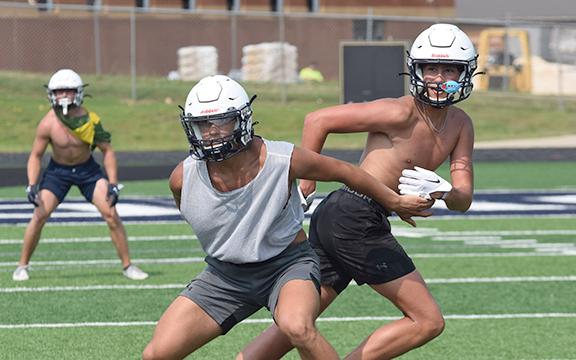 WCHS linebacker Jon Scott, left, covers John Phillips during Tuesday's workout at Warrior Stadium.  (Photo/Mark Turner)