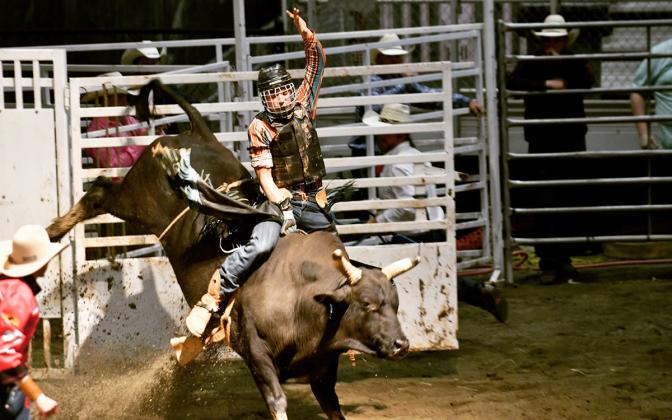 Nathan Calhoun competes in a bull riding competition during a recent high school rodeo.  (Photos/Submitted))