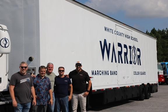Warrior Band Director Michael Pickett and Band Booster President Donnie Filaski accept the truck and graphic wrap donation from Turbo’s Steve Syfan, Nicky Smith and Mike Trump. (Photo/submitted)