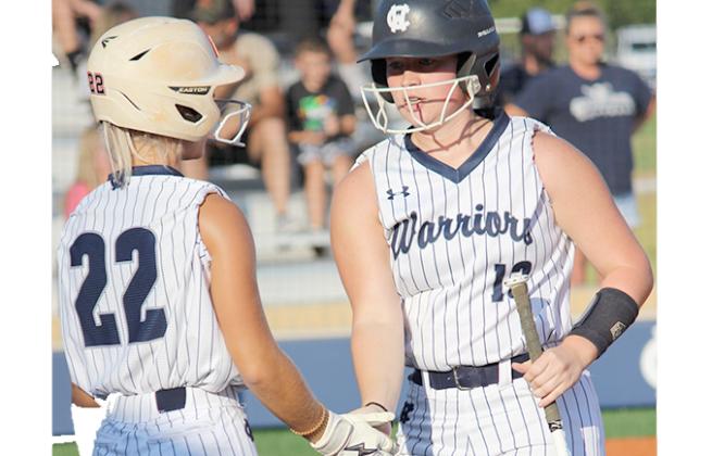Emma Hare, left, congratulates Gabby Whiddon after scoring a run in sixth inning during the region win Monday over West Hall. (Photo/Mark Turner)