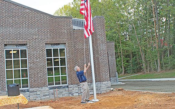 Commissioner Terry Goodger raises the American flag in remembrance of the 9/11 attacks. (Photo/Noah Johnson)