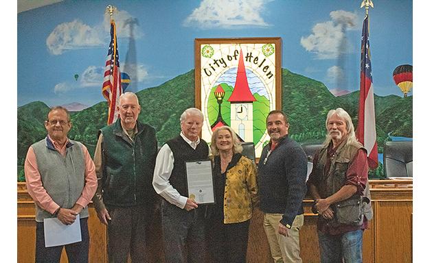 Commissioners Lyn Holcomb, Edwin Nix, Craig Bryant and Chairman Travis Turner present Mayor Jeff Ash and his wife, Paula with the proclamation making Dec. 12 Jeff Ash Day. (Photo/Noah Johnson)