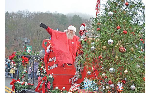 Santa, wearing a rain poncho, waves to the crowd at the center of town during Helen’s Annual Christmas Parade on Saturday. Look for more photos on Page 14A. (Photo/Samantha Sinclair)