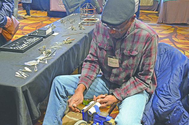 Nathaniel Williamson sizes a ring for a customer at his booth at last year’s Fireside Arts and Crafts Show at Unicoi State Park and Lodge. (file  photo)