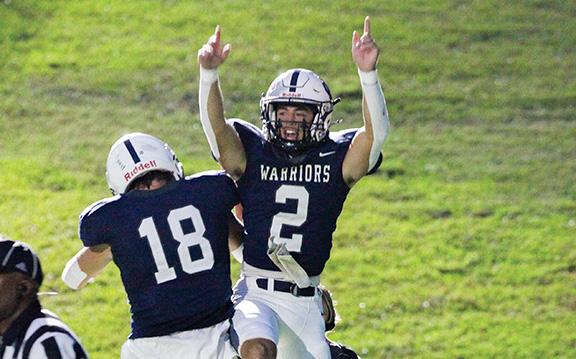 Tripp Nix, right, celebrates with Brayden Roach after scoring one of his three rushing touchdowns in the Warriors' win over East Jackson Friday night in Cleveland. (Photo/Staci Sulhoff)