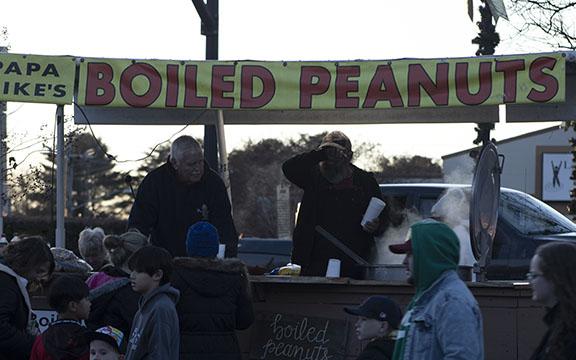From left, Mike “Papa Mike” Meaders and Tim Thomas serve up boiled peanuts to a hungry crowd of evening shoppers at the Christmas in Mountains Market on Dec. 7. (Photo/Hannah Caudell)