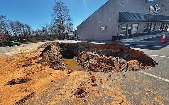 The sinkhole that opened up in a parking lot between Dalton Eye Car and Anytime Fitness. (Photo/Basil Ray)