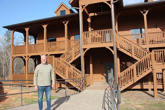 Woodlands Camp and Retreat Center Director and CEO John Estes stands beside one of two cabins nearing completion on the west side of the property off Old Blue Creek Road in Cleveland. (Photos/Denise Etheridge)