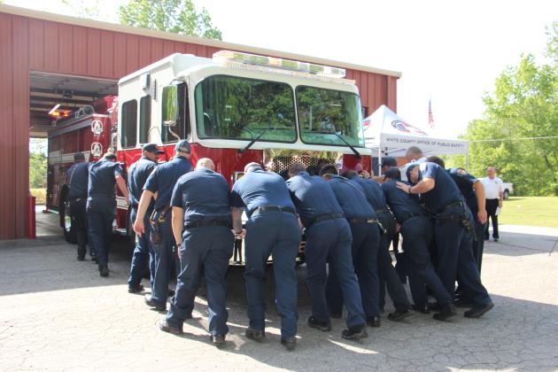 Firefighters and EMTs muscle the county’s new fire truck into the Station 4 bay during a traditional Push-In ceremony on April 21. (Photo/Denise Etheridge)