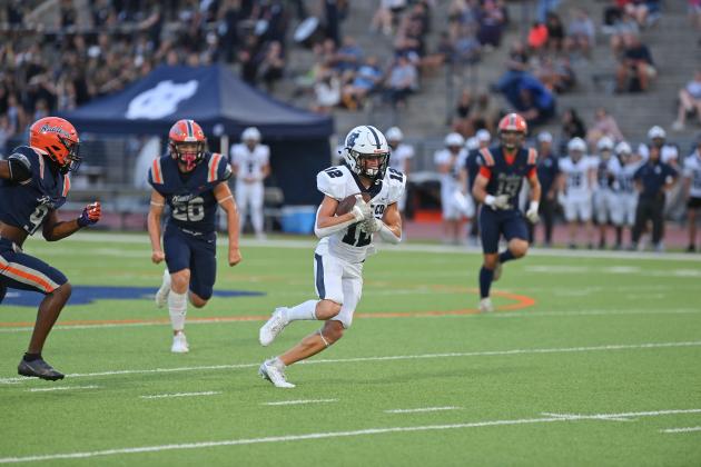 Zach Godfrey carries the football for the Warriors. (Tom Askew photo)