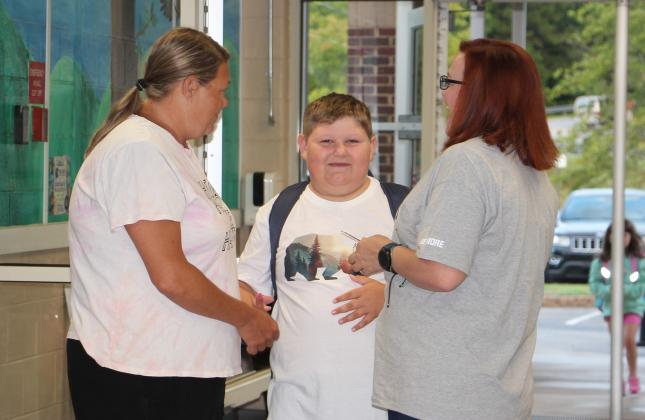 Christy McGuire, left, and her son Brayden Ballard speak with Tesnatee Gap Elementary School secretary Kristen Dennis, right, on Aug. 1. DENISE ETHERIDGE/WCN