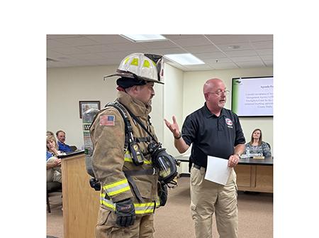 Public Safety Director David Murphy, right, points out the cost of outfitting a firefighter using Assistant Chief Josh Taylor as a model. The tank on his back is a self-contained breathing apparatus. LINDA ERBELE/WCN