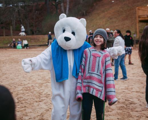 The Winter Bear Plunge mascot greets a young visitor to Unicoi State Park on Jan. 3. PHOTO COURTESY OF JESSI TAYLOR/UNICOI STATE PARK