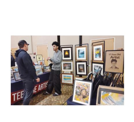Artist Tyrus Mosley, 17, of Covington speaks with a visitor to Unicoi State Park &amp; Lodge during WinterFest last Saturday. DENISE ETHERIDGE/WCN