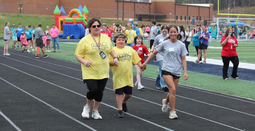 Eli Crowder heads to the finish line of a 50-meter race along with Amanda Maring, right, and Shalyn Vandiver.
