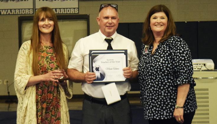 On April 30, Mark Adams, center, was presented with the White County School System Teacher Award by Leann Fuller, the 2025 WCSS Teacher of the Year, left, and White County School Human Resources Director Laura Corley, right, during a ceremony in the White County Middle School gym. DENISE ETHERIDGE/WCN
