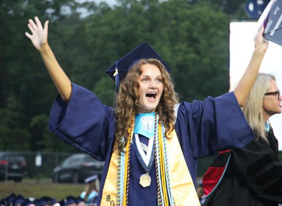 Caroline Tatum throws her hands in the air in celebration after receiving her diploma during the 2026 White County High School graduation ceremony. CARLY HENDERSON/WCN